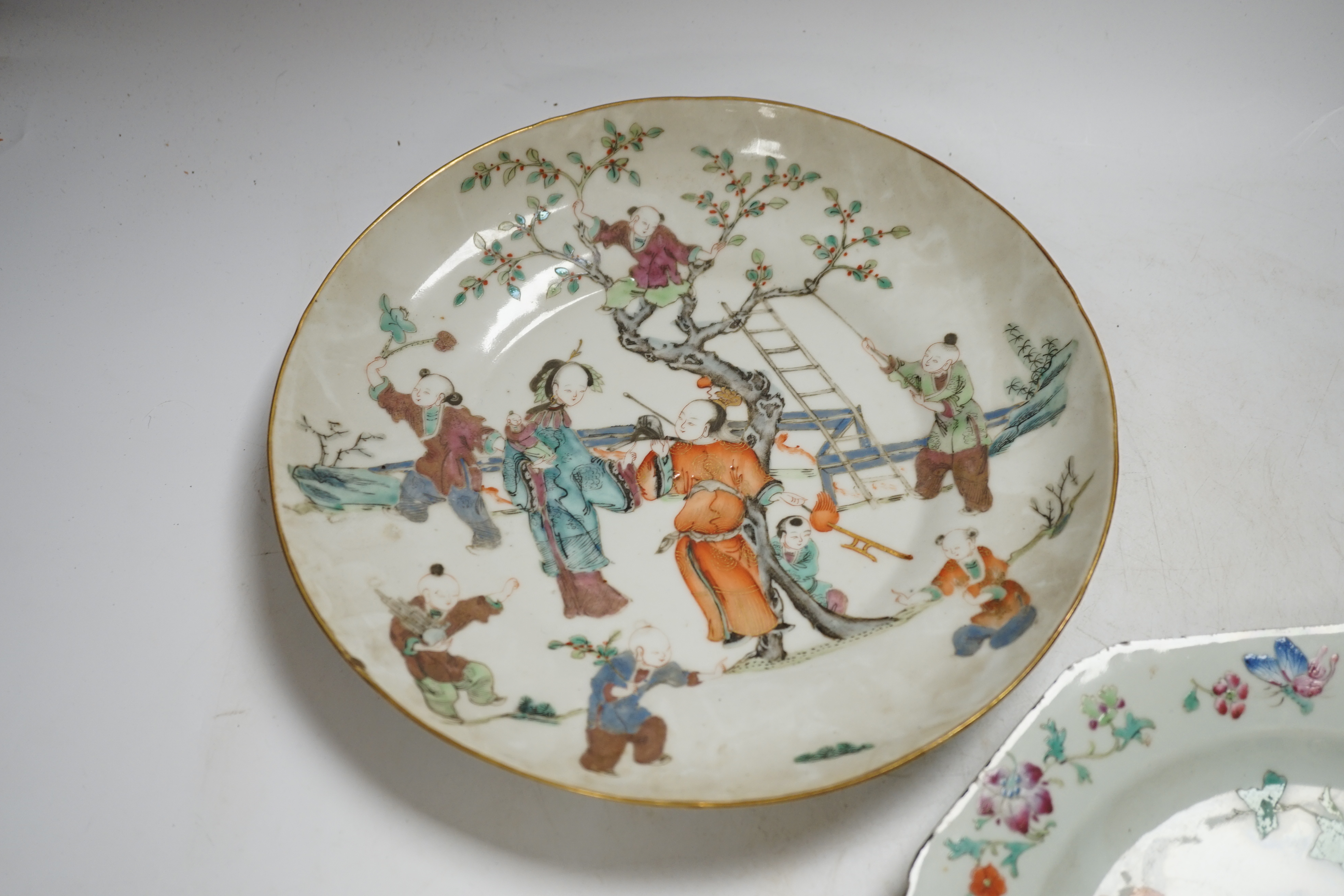 A Chinese famille rose ‘boys’ saucer dish, Tongzhi seal mark and probably of the period (1862-1874) and an 18th century Chinese famille rose octagonal ‘cranes’ plate, dish 25cm diameter